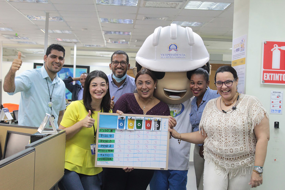 El equipo del departamento de Desarrollo Institucional y Calidad en la Gestión de la Administradora de Subsidios Sociales (Adess) y Qualy, la mascota del Sistema de Gestión Integrado de las instituciones que conforman el Gabinete de Coordinación de Políticas Sociales (GCPS) y símbolo de la calidad, recorrieron las instalaciones de la entidad para verificar el cumplimiento de los lineamientos de separación y gestión de residuos.